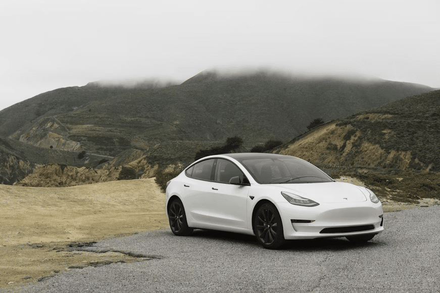 A Tesla parked on a cliff.