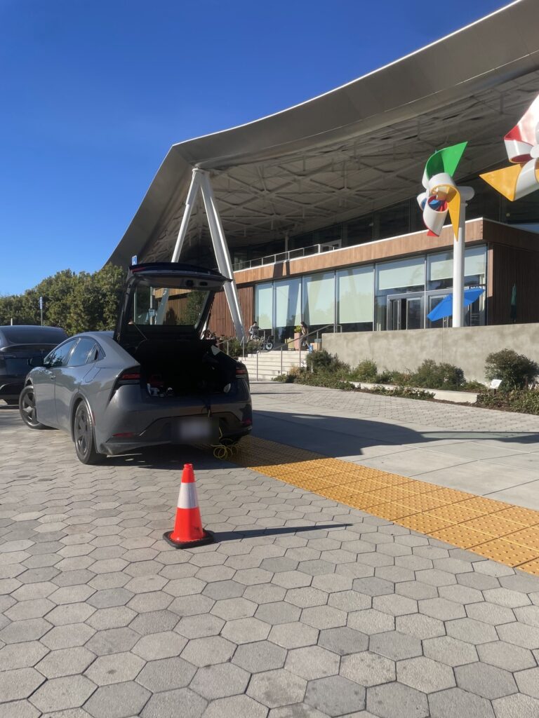 The service vehicle parked with its hatch open and an air line run out
