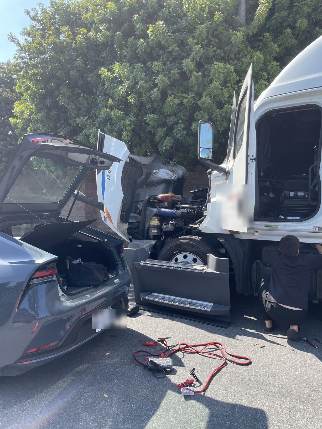 SOS Roadside technician jump starting a semi-truck at the roadside