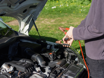 A person jumpstarts a car.
